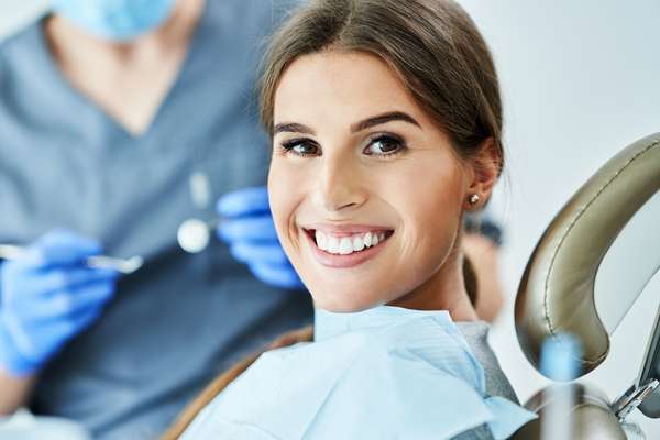 smiling young lady in a dentist chare getting treatment