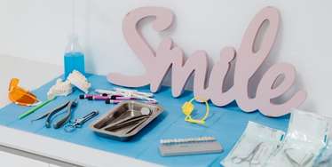 Springdale Dental Office table with dental instruments and a sign that says smile